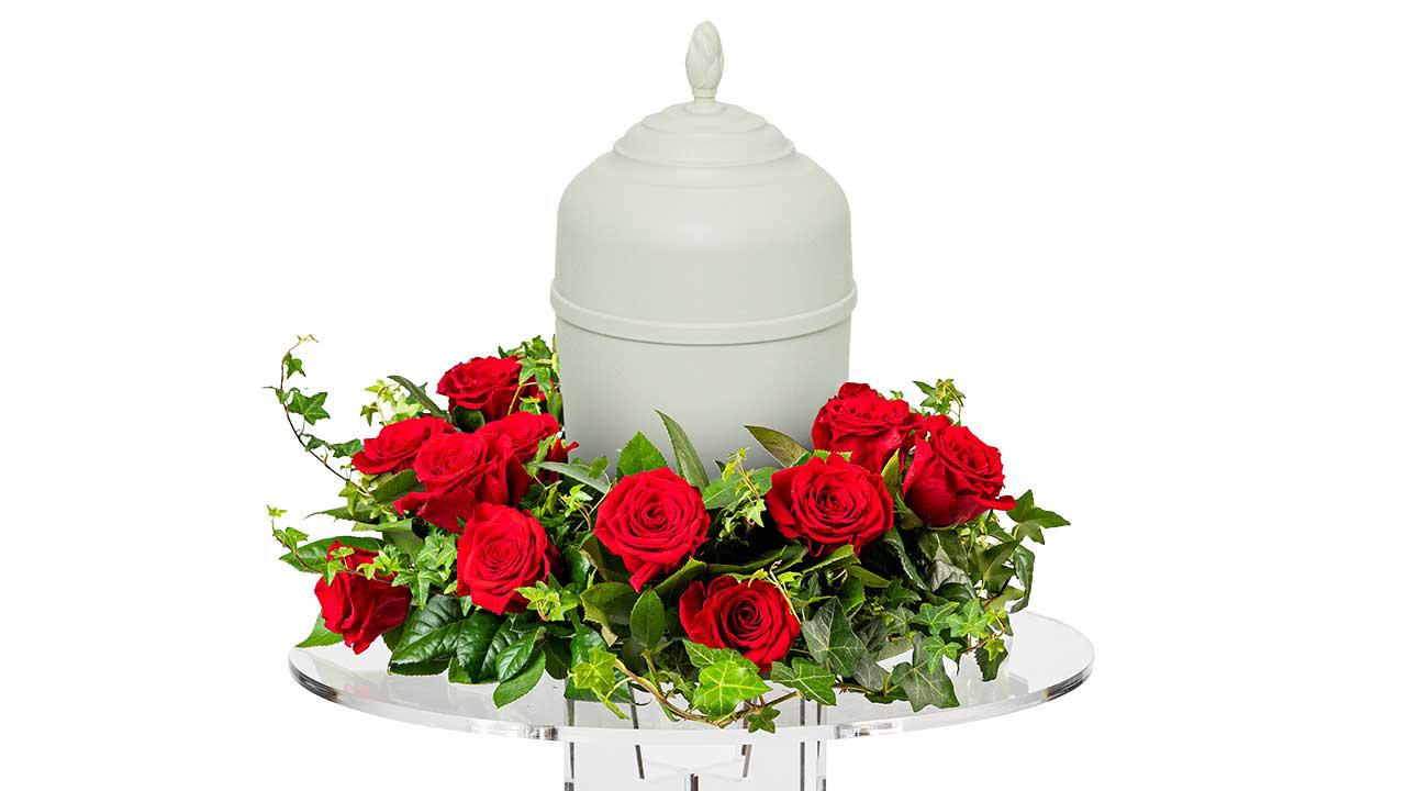 Urna med blomdekoration av röda rosor.